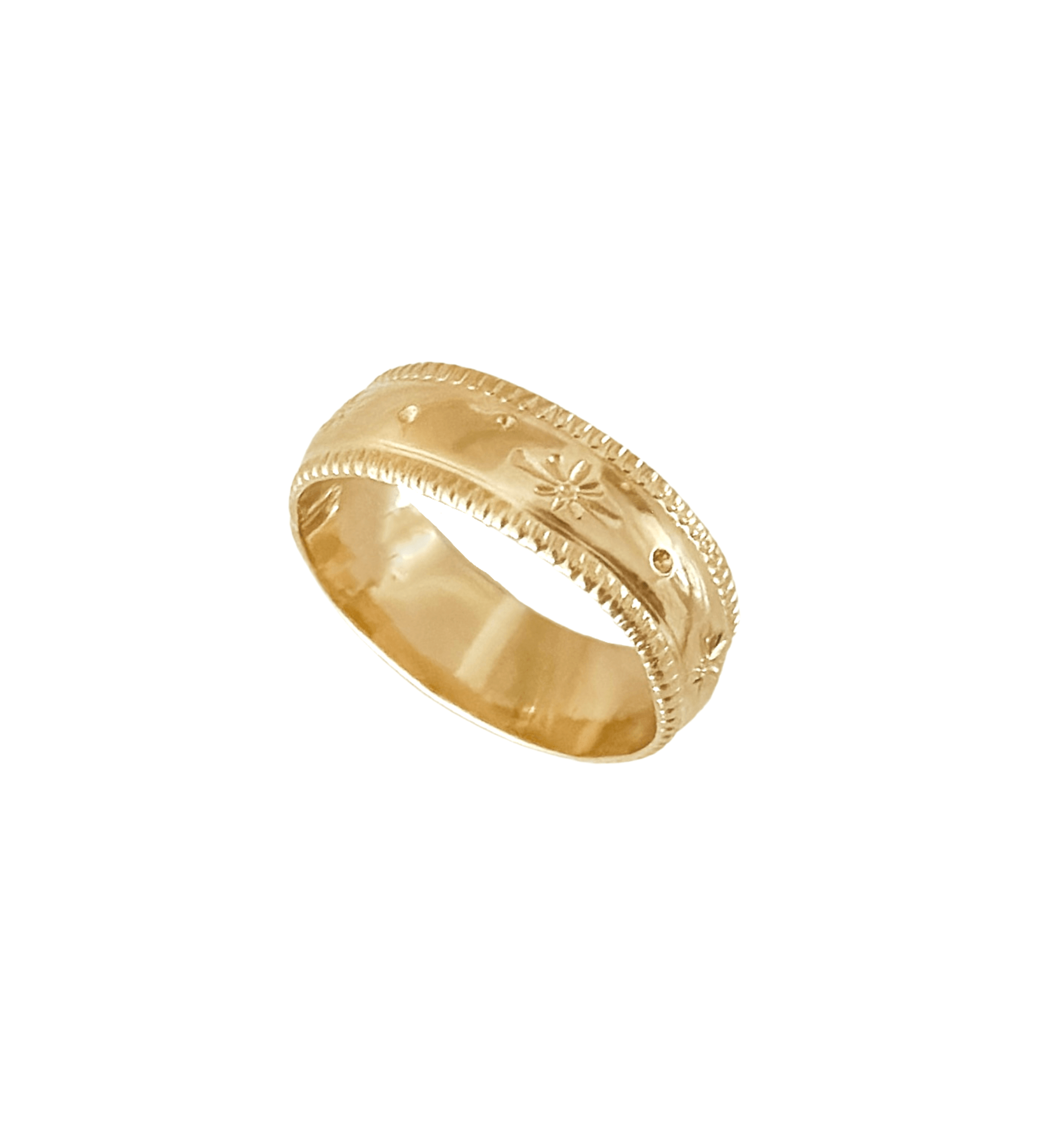 The Stardust Ring, embellished with engraved floral and dot patterns, boasts a polished central band and textured edges in 14k gold fill. This celestial piece of jewelry adds a touch of elegance to any outfit.