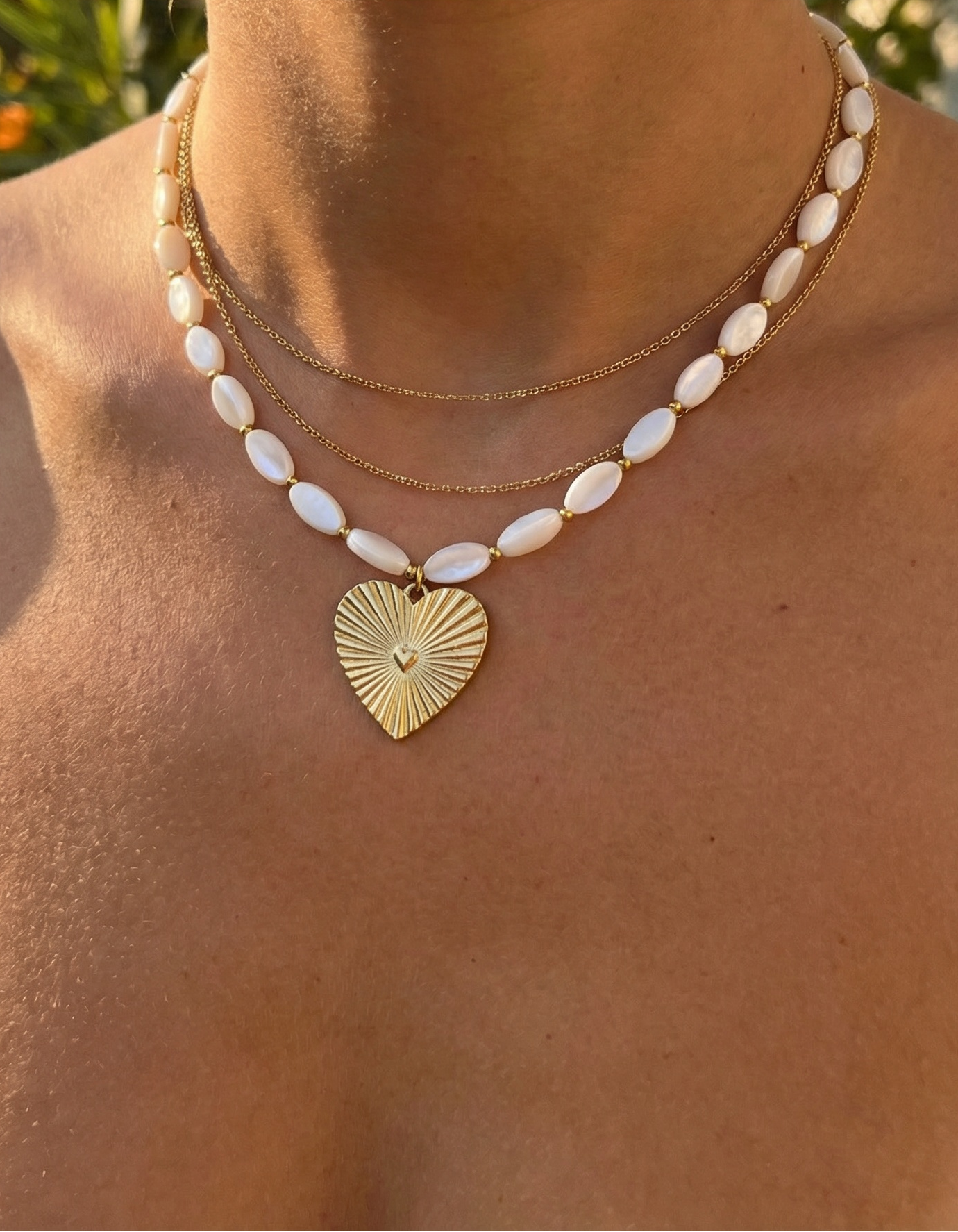 necklace with mother of pearl beads and a textured heart pendant