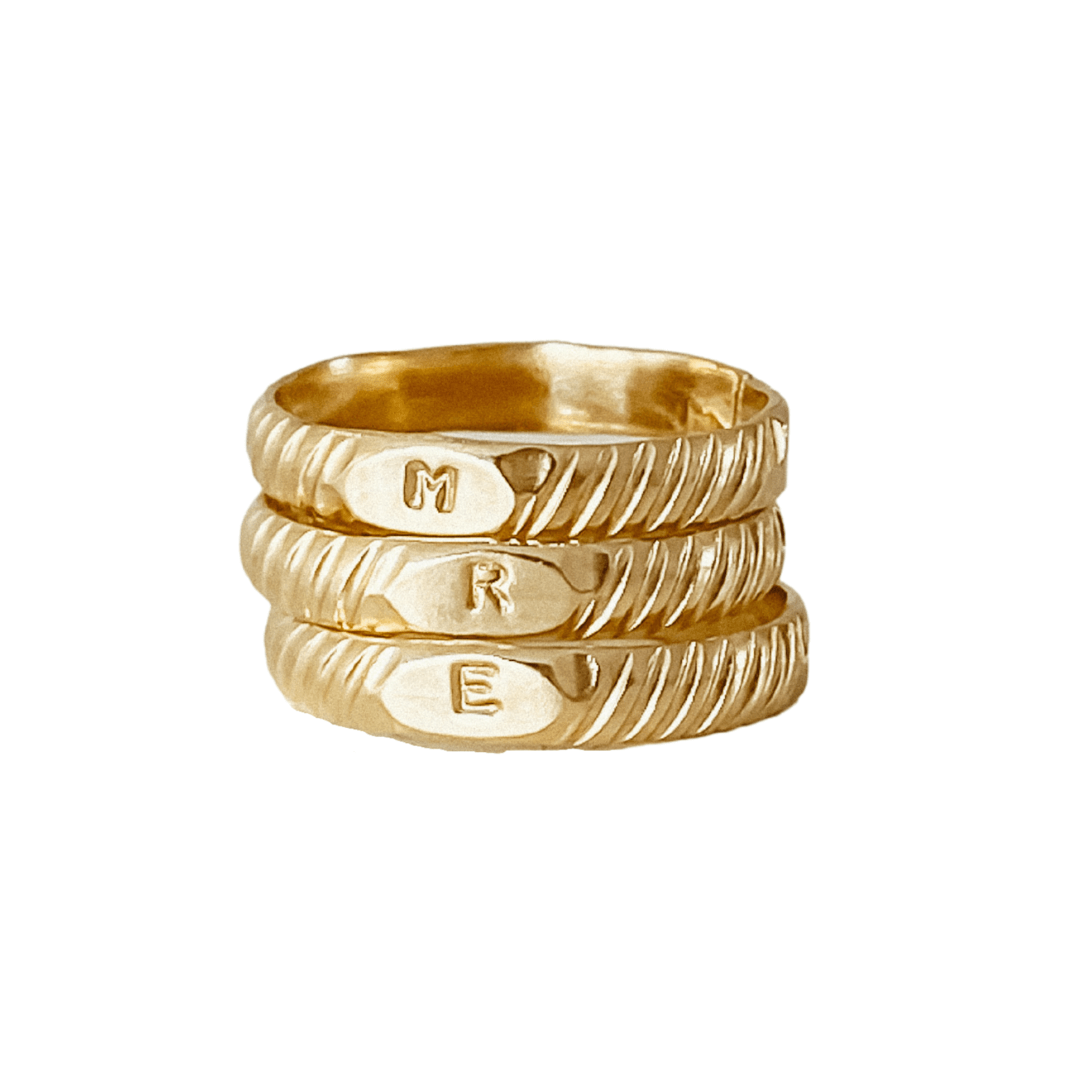 A stack of three personalized Initial Signet Rings, each engraved with the letters "M," "R," and "E," featuring a textured, braided design in 14k gold filled.